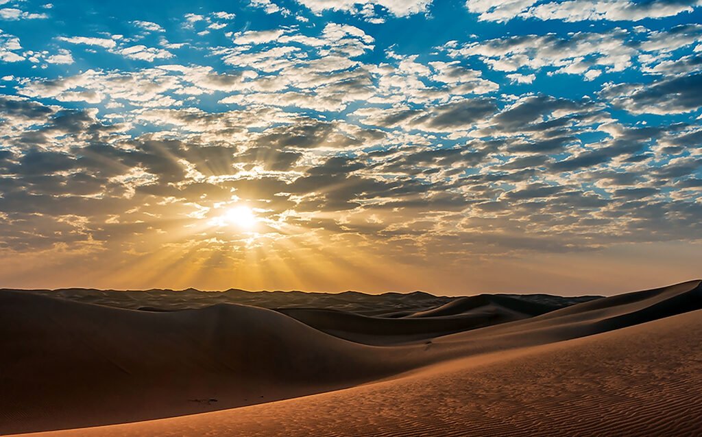 Sunrise over desert dunes