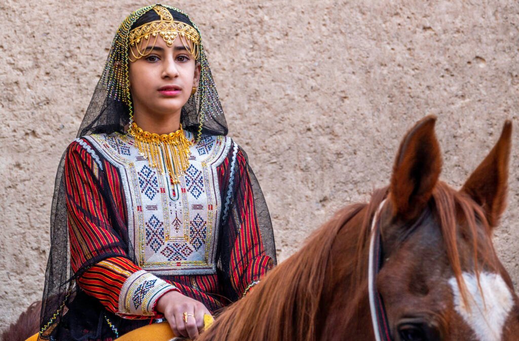 Portrait of a woman seated beside a horse